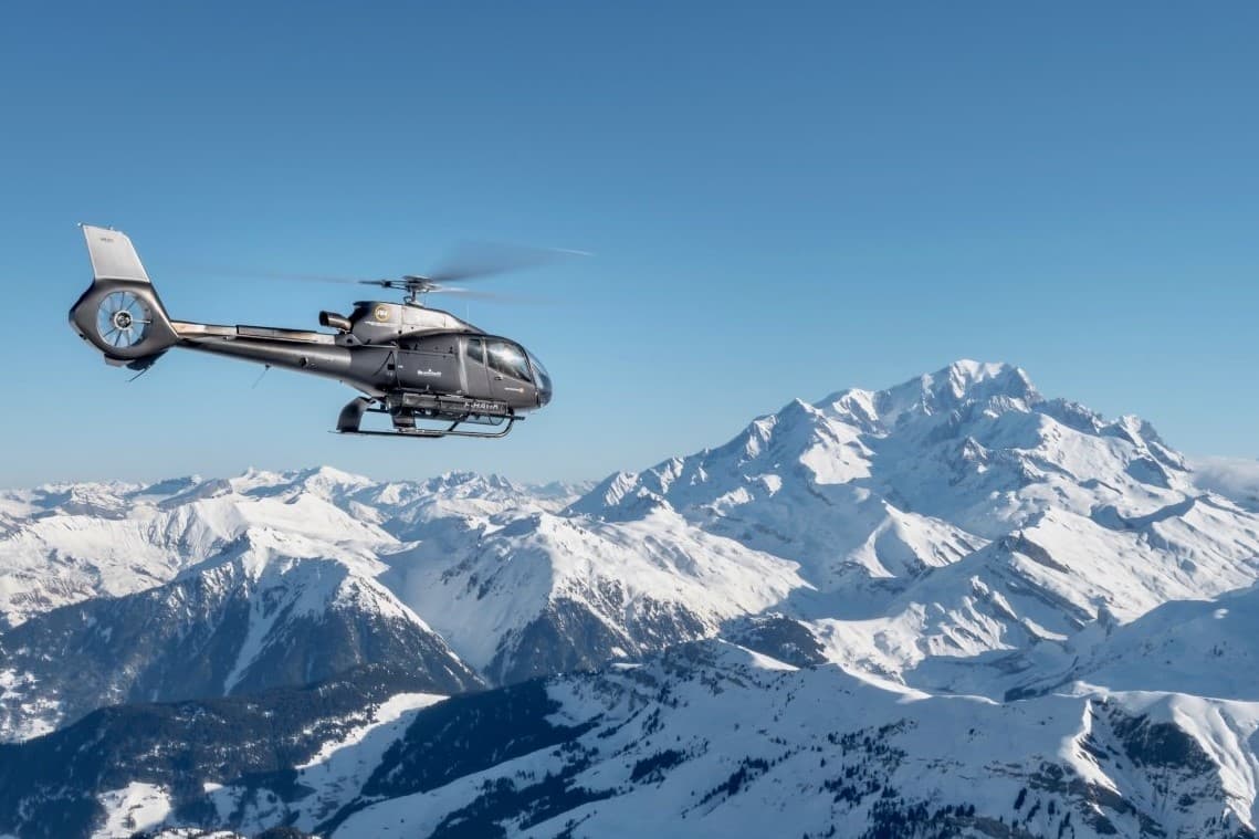 Helicopter in the sky with snowy mountains in the foreground